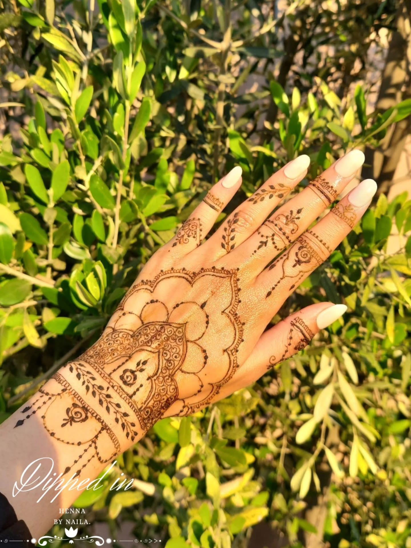 Bold flower on the back of the hand against bright leaves