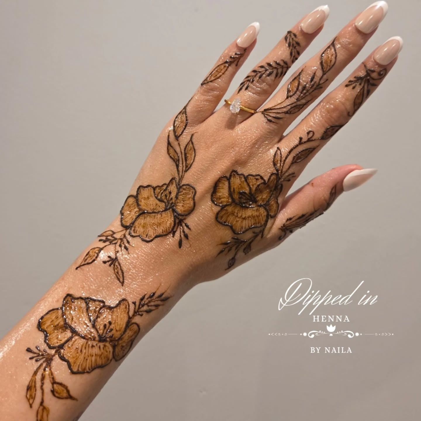 Floral henna on the hand against a pale background
