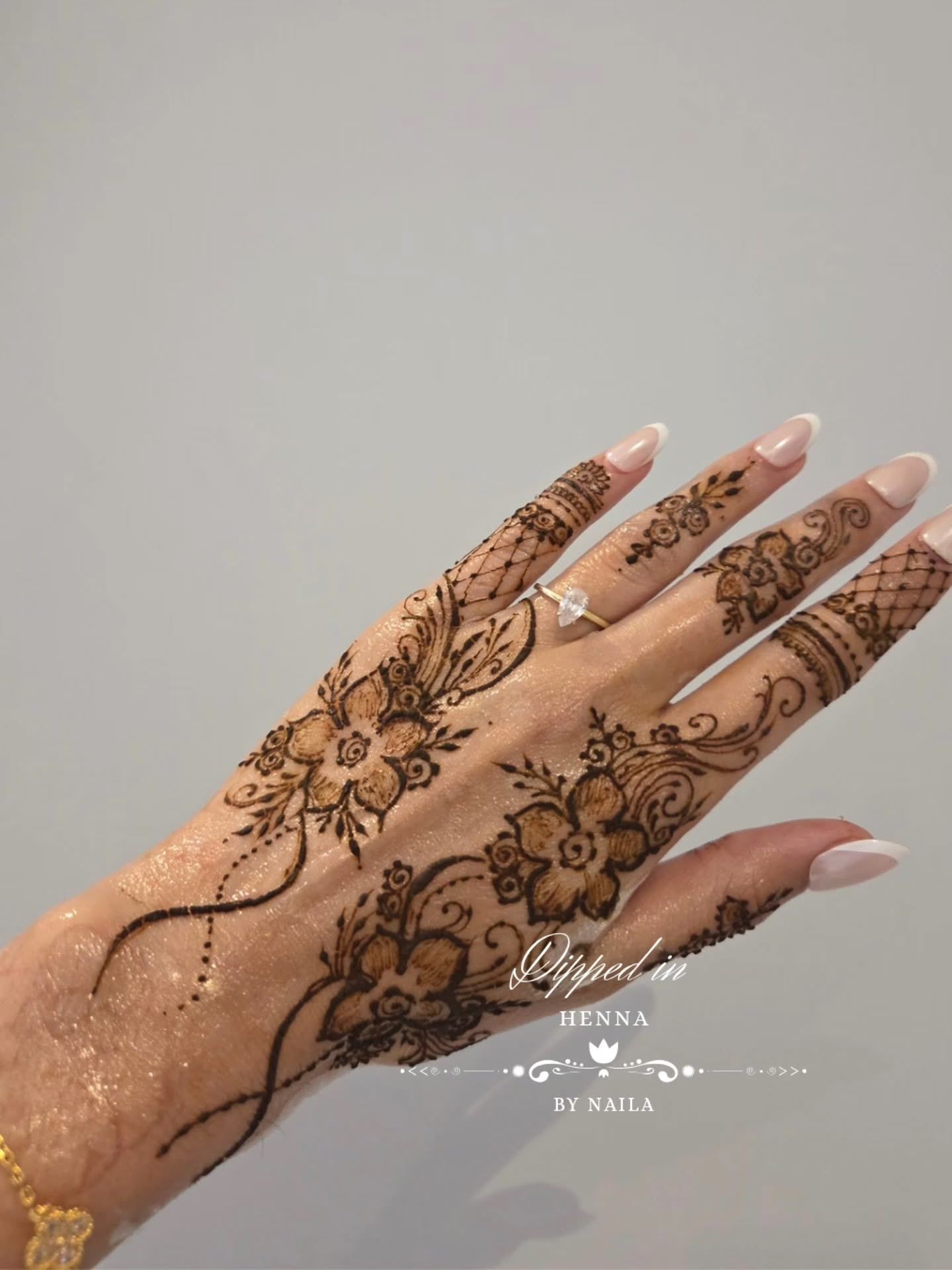 Soft floral henna across the back of the hand