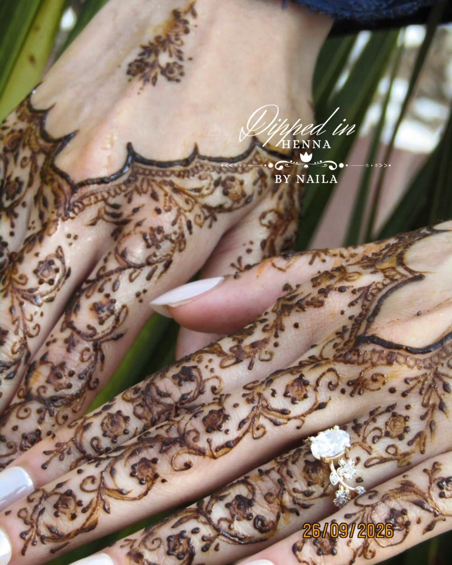 Close-up of fine, lace-like henna on the back of the hands