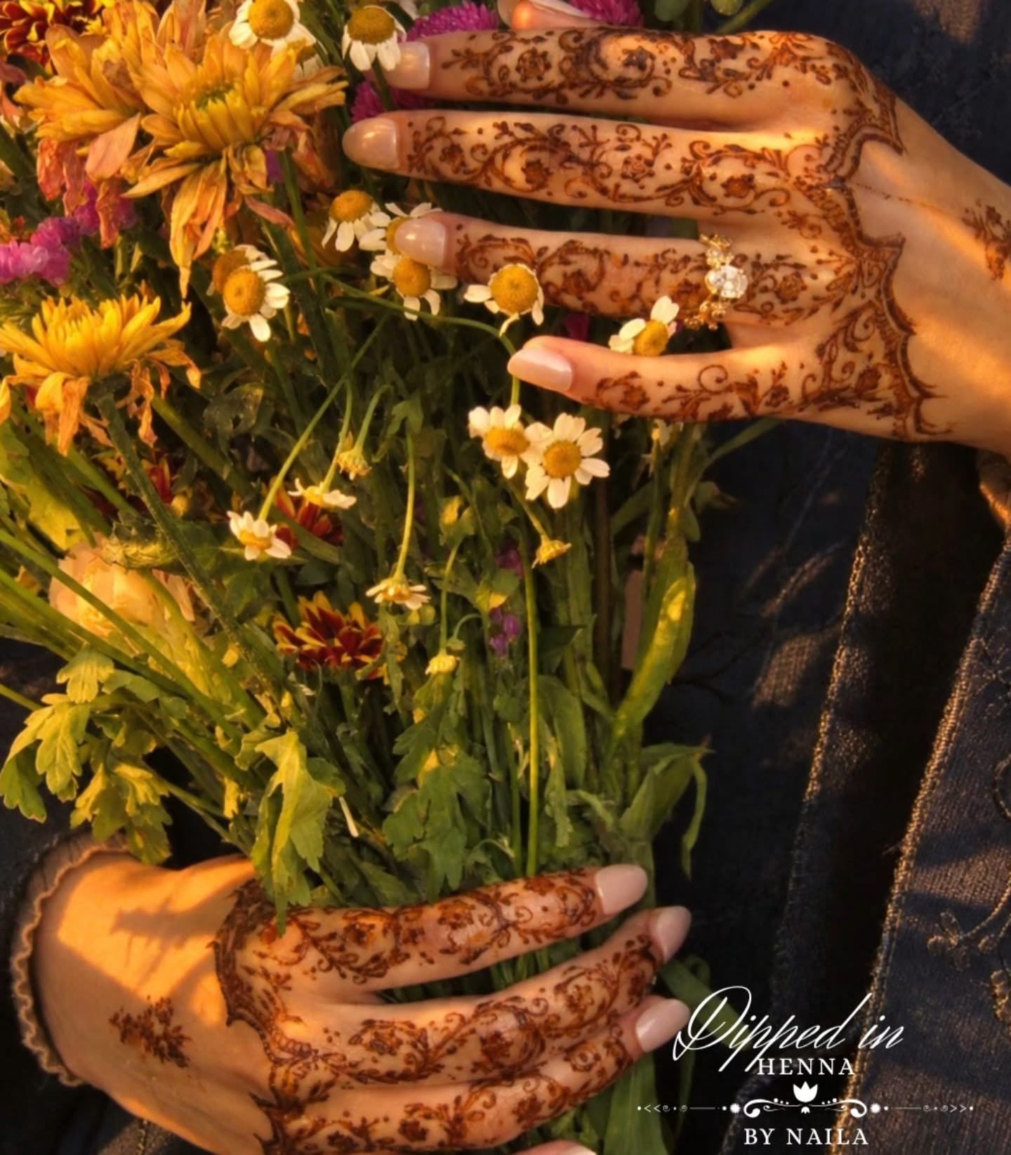 Hennaed hand with a bouquet of wildflowers