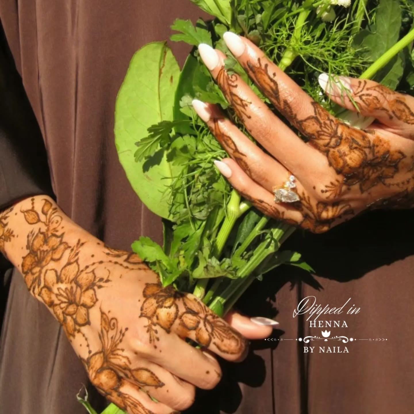 Hennaed hands holding fresh greens