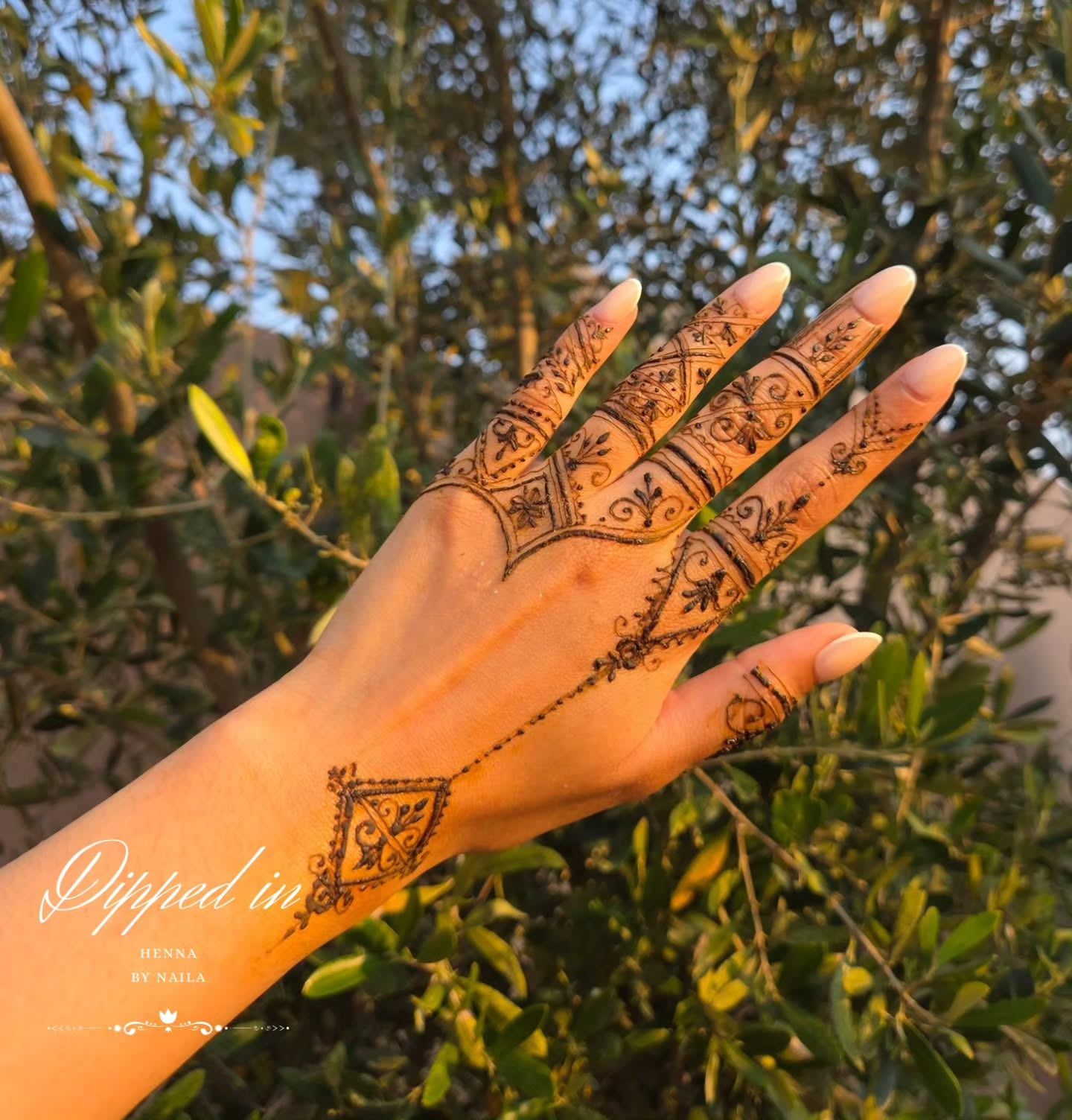 Fingers-to-wrist henna: fine design on the back of the hand with a chain to the wrist